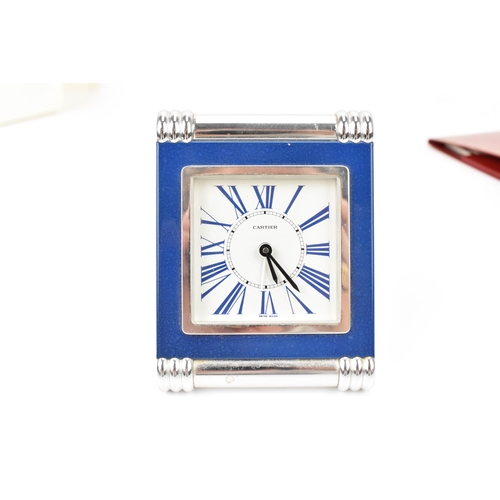 49 - A Cartier travel alarm clock in a rectangular strut frame with turned and ribbed chrome supports, La... 