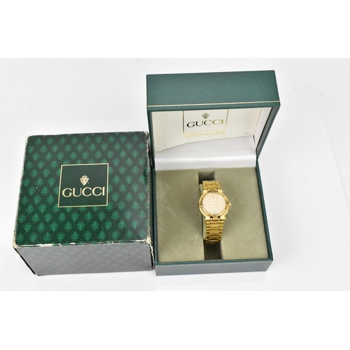 50 - A Gucci, quartz, ladies, gold plated wristwatch, having a champagne dial with baton markers and date... 