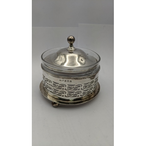 118 - Silver and white metal to include a silver lidded jar and spoon, a floral white metal overlaid decan... 