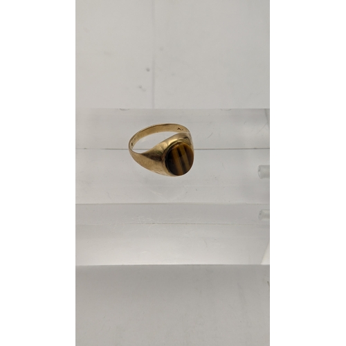 123 - A gold coloured ring set with a tigers eye, a 9ct gold ring set with a moon stone an a white gold ri... 