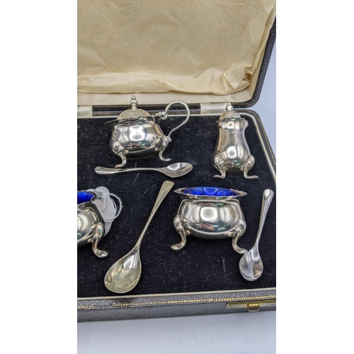 155 - A silver condiment set comprising of two salts, two peppers and a mustard and silver plated spoons
L... 