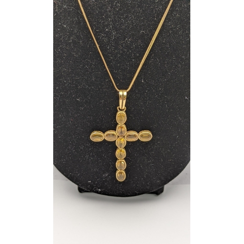 29 - A yellow metal pendant fashioned as a cross tested as 18ct gold on a gold plated necklace, total wei... 