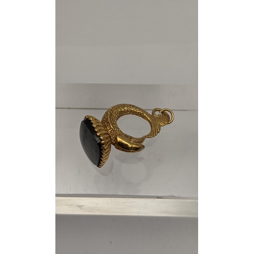 69 - A yellow metal and black onyx fob fashioned as a fish, tested as 9ct gold, together with a 9ct gold ... 