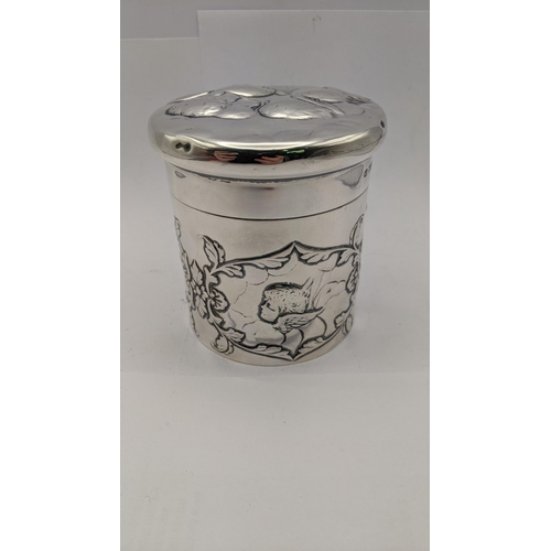 98 - A silver lidded dressing table jar having floral embossed decoration with angles, together with a ma... 