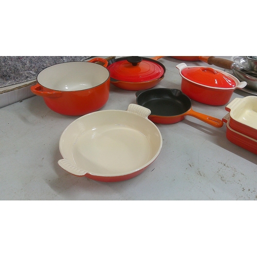 241 - Le Creuset pots and pans to include a frying pan, serving dish and others, mostly in orange
Location... 