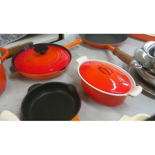 241 - Le Creuset pots and pans to include a frying pan, serving dish and others, mostly in orange
Location... 