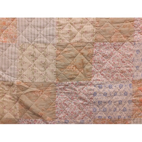 123 - A late 20th Century patchwork quilt in pale greens, blues, pinks and peach colours with floral and g... 