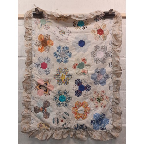 124 - A 20th Century handmade quilt in browns, cream, white, pinks, greens and blues having a geometric sq... 