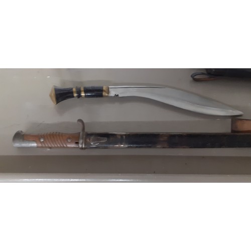 390 - An early 20th century German bayonet, together with a kukri in a leather scabbard Location:BWR