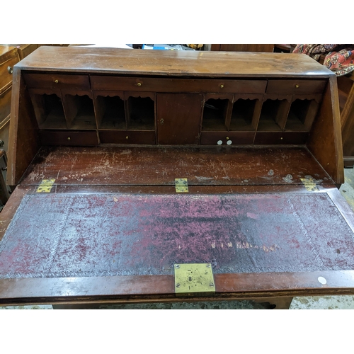 371 - A Georgian mahogany cross banded bureau, fall flap with fitted pigeonhole and drawer interior, above... 