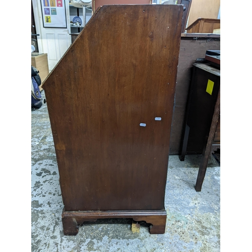 371 - A Georgian mahogany cross banded bureau, fall flap with fitted pigeonhole and drawer interior, above... 