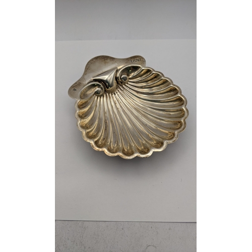 423 - A silver butter dish hallmarked 1897 fashioned as a seashell along with a silver floral engraved cig... 