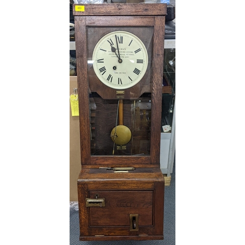 453 - An early/mid 20th century oak carved clocking-in clock, the dial inscribed Boyhan Office Furniture C... 