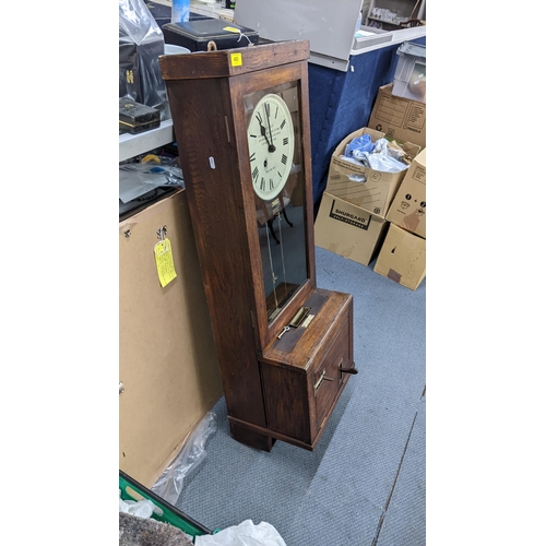 453 - An early/mid 20th century oak carved clocking-in clock, the dial inscribed Boyhan Office Furniture C... 