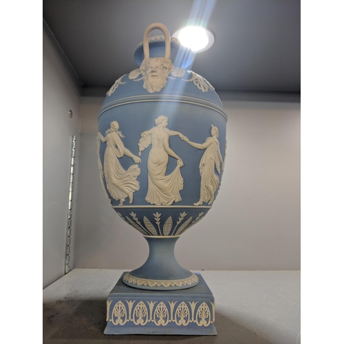 496 - A blue and white Wedgwood jasperware twin handled urn vase decorated with maidens, raised on a squar... 