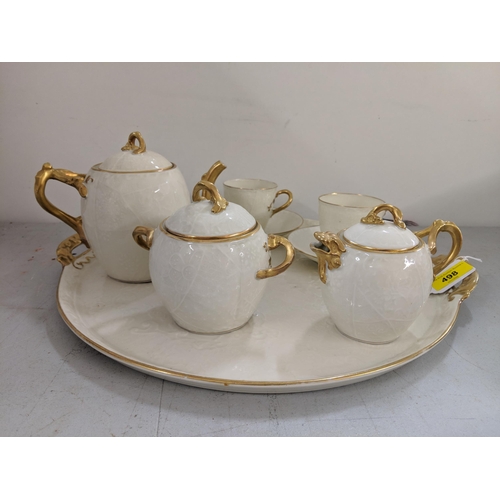 498 - A late 19th/early 20th century Limoges cabaret set comprising a tray, teapot, sugar bowl, milk jug a... 