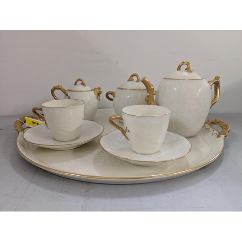 498 - A late 19th/early 20th century Limoges cabaret set comprising a tray, teapot, sugar bowl, milk jug a... 