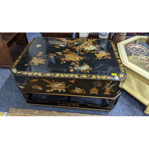 507 - An Oriental black lacquered octagonal coffee table, the top decorated with birds amongst flowers and... 