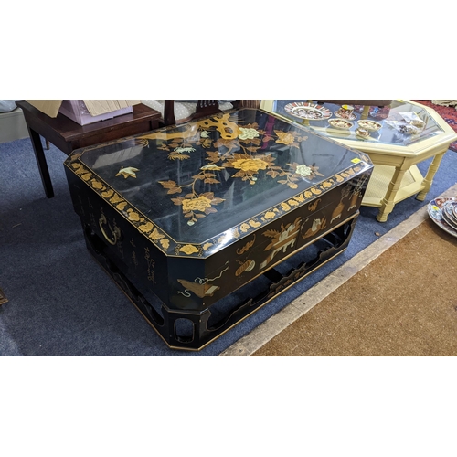 507 - An Oriental black lacquered octagonal coffee table, the top decorated with birds amongst flowers and... 