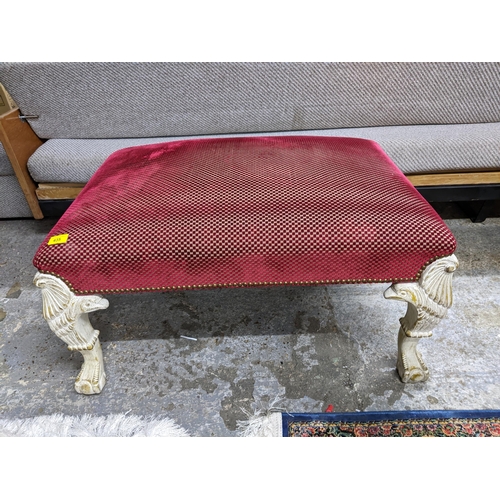 435 - A large footstool upholstered in a red checkered pattern, on white painted legs in the form of an ea... 