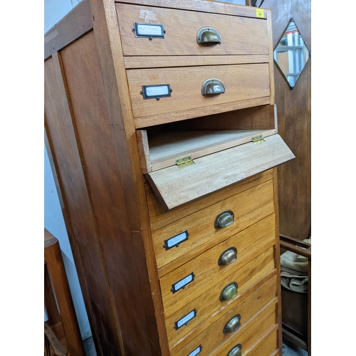 300 - A hardwood filing cabinet of twelve drawers with brass handles on stile feet 164cm x 57cm x 66cm Loc... 