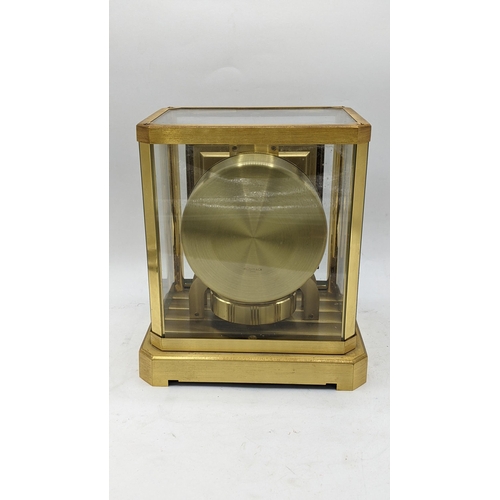 114 - A Jaeger Le Coultre Atmos clock circa 1960s, in a gilt brass case, having a square cream chapter rin... 