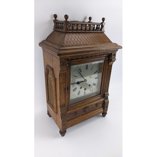 116 - A late 19th century oak bracket clock, the case of architectural design having a handle to the top e... 