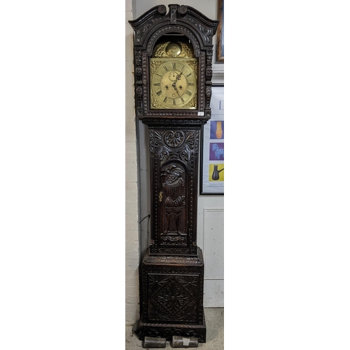 67 - An 18th century and later longcase clock, the heavily  carved oak case having broken swan neck pedim... 