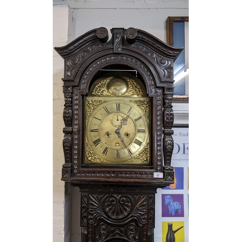 67 - An 18th century and later longcase clock, the heavily  carved oak case having broken swan neck pedim... 