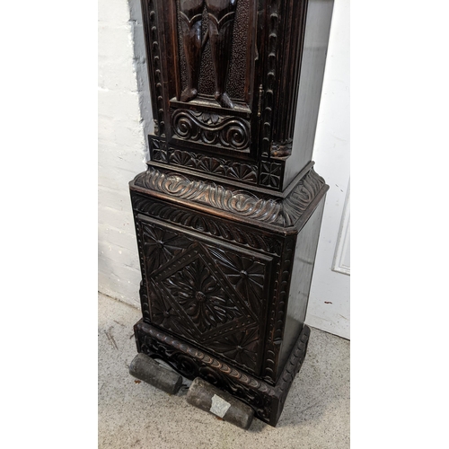 67 - An 18th century and later longcase clock, the heavily  carved oak case having broken swan neck pedim... 