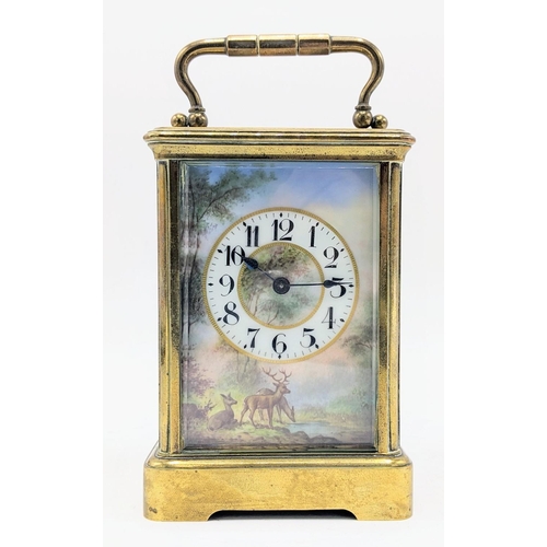 85 - An early 20th century brass cased carriage clock, having a painted dial depicting deer drinking by a... 