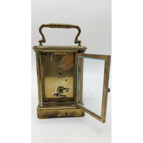 85 - An early 20th century brass cased carriage clock, having a painted dial depicting deer drinking by a... 