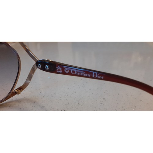 18 - Christian Dior- A pair of 1980's over-sized gold tone and brown sunglasses having lilac and pink len... 