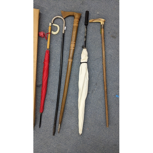 290 - Walking sticks and umbrellas to include an early 20th century horn handled stick with a white metal ... 