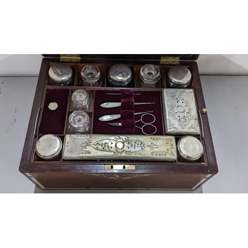 365 - A Victorian rosewood and mother of pearl vanity box enclosing silver plated and glass jars and boxes... 