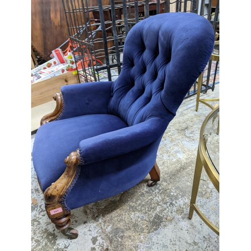 393 - A Victorian walnut framed upholstered nursing chair, blue button back upholstery, turned front legs ... 