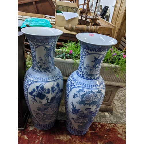 402 - Two floor standing late 20th century Oriental porcelain vases, each decorated with reserves of birds... 