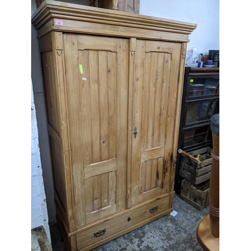 427 - A Victorian pine twin door wardrobe, stepped cornice above twin panel fielded doors, above a base dr... 