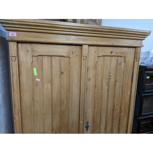 427 - A Victorian pine twin door wardrobe, stepped cornice above twin panel fielded doors, above a base dr... 