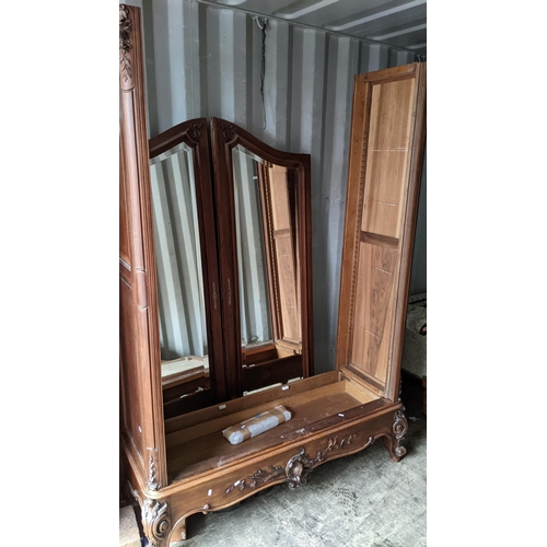 448 - A late 19th century walnut armoire having a carved floral and scroll frame, two mirrored doors, fitt... 