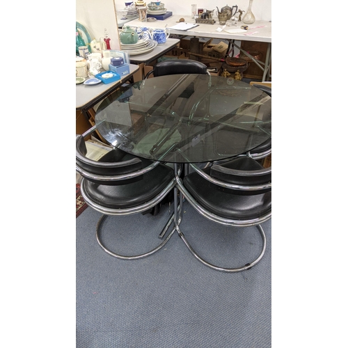 470 - A mid 20th century smoked glass topped dining table, together with four matching leather and chrome ... 