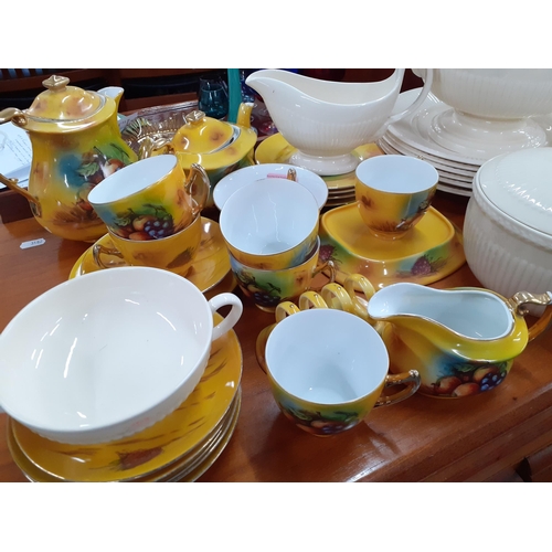 518 - A Phoenix china yellow ground tea and breakfast service decorated with images of fruit together with... 