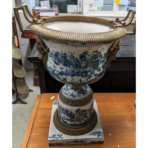 403 - A pair of modern Chinese style pedestal vases with brass mounts decorated with landscapes in blue an... 