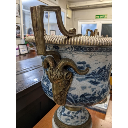 403 - A pair of modern Chinese style pedestal vases with brass mounts decorated with landscapes in blue an... 