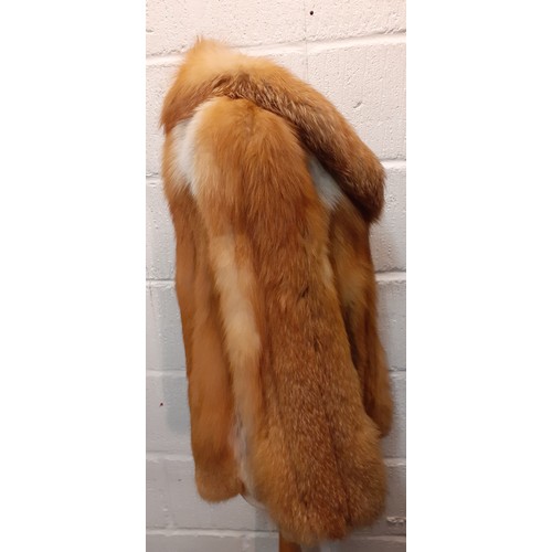 77 - A 1970's red fox fur jacket having vertical brown leather insertions, 2 front pockets and a shawl co... 