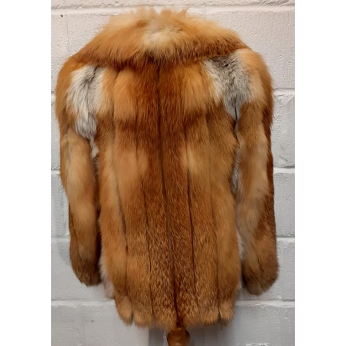 77 - A 1970's red fox fur jacket having vertical brown leather insertions, 2 front pockets and a shawl co... 