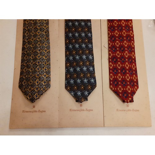 107 - Ermenegildo Zegna-Three silk ties in various colours and designs with original tie slip packets.
Loc... 