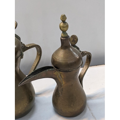 251 - Two Middle Eastern brass, possibly Ottoman Dallah coffee pots, marked to sides, tallest 30cm high
Lo... 