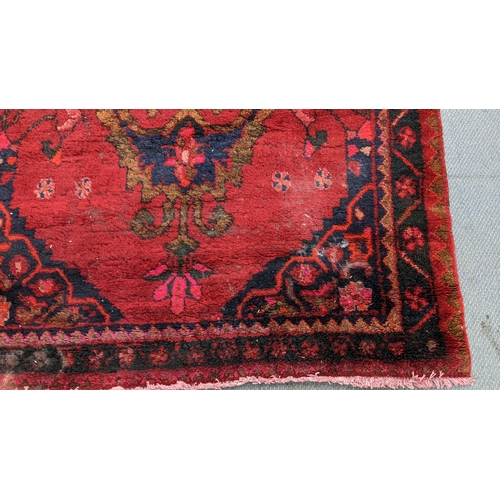 22 - A Persian hand woven red ground rug having a central motif and repeating patterns, 260cm x 145cm
Loc... 