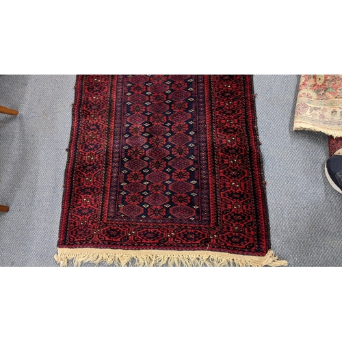 23 - A Persian hand woven rug having a red ground, repeating motifs and tasselled ends, 157cm x 82cm
Loca... 